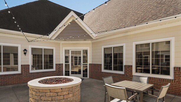 A patio with a stone fire pit, outdoor seating, and string lights. - Residence Inn by Marriott Scranton (Scranton)