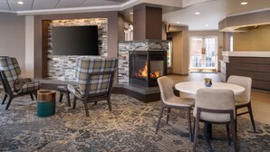 A modern lounge area with a fireplace, comfortable seating, and a flat-screen TV.
