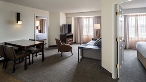 A hotel room with a bed, a desk with a chair, a television, and a window with curtains. - Residence Inn by Marriott Washington, DC/Dupont Circle (Washington)