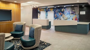 A reception area with a modern design, including a reception desk, seating area with armchairs, and a large abstract painting on the wall. - Residence Inn by Marriott Washington, DC/Dupont Circle (Washington)