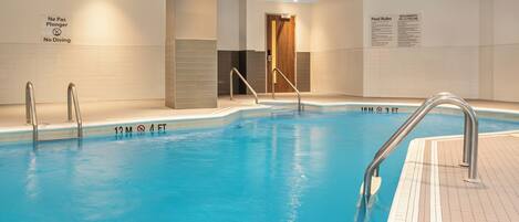 An indoor swimming pool with a sign indicating a maximum of 10 swimmers.