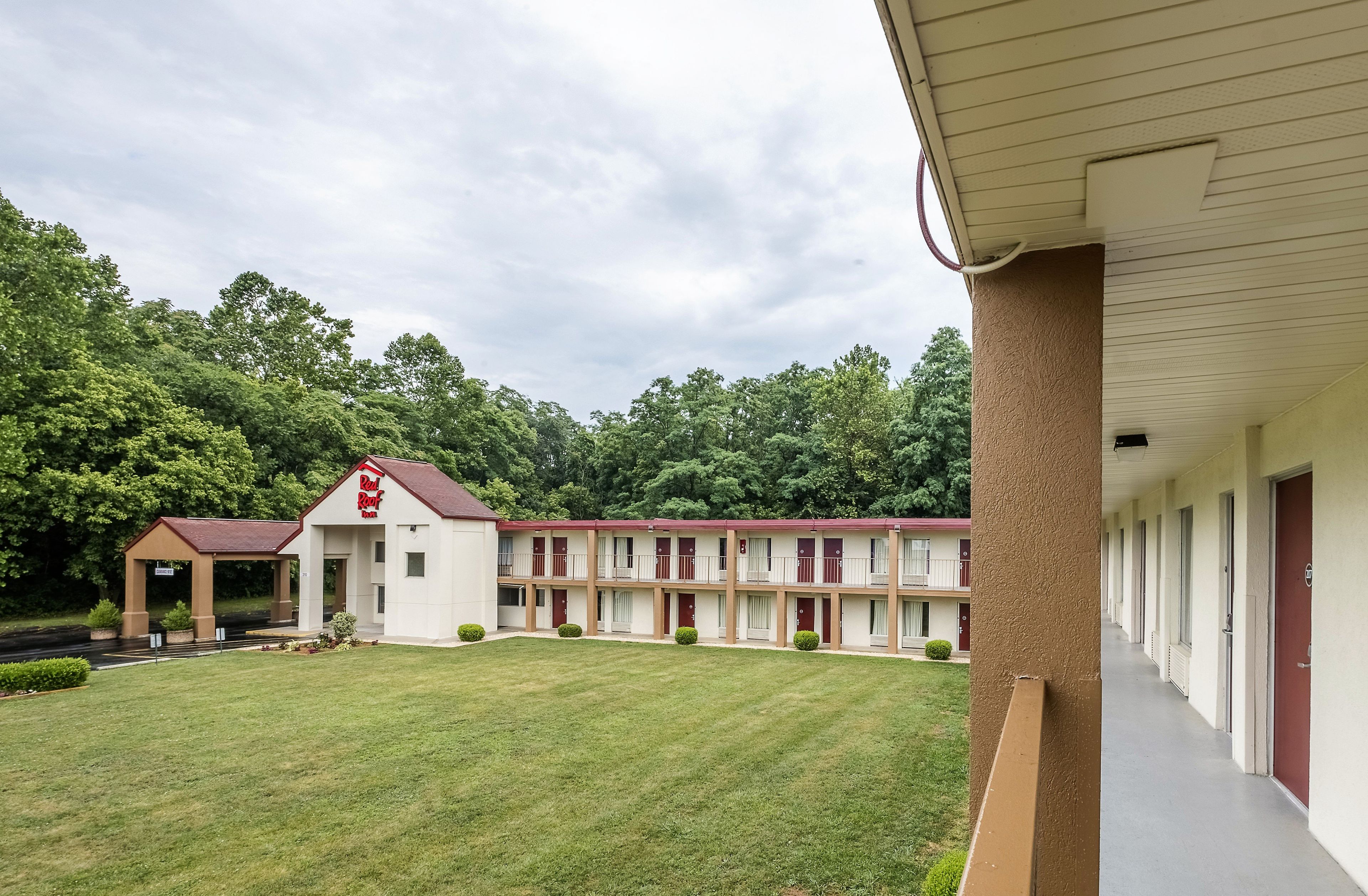 A motel with a central courtyard, multiple rooms with balconies, and a parking area.