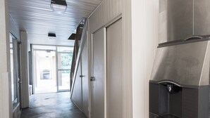 Un pasillo con un electrodoméstico de acero inoxidable, una puerta y un ventanal.