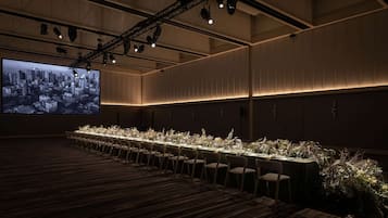 Une salle de conférence équipée d’une longue table, de chaises et d’un grand écran sur lequel est projetée une vue panoramique de la ville.