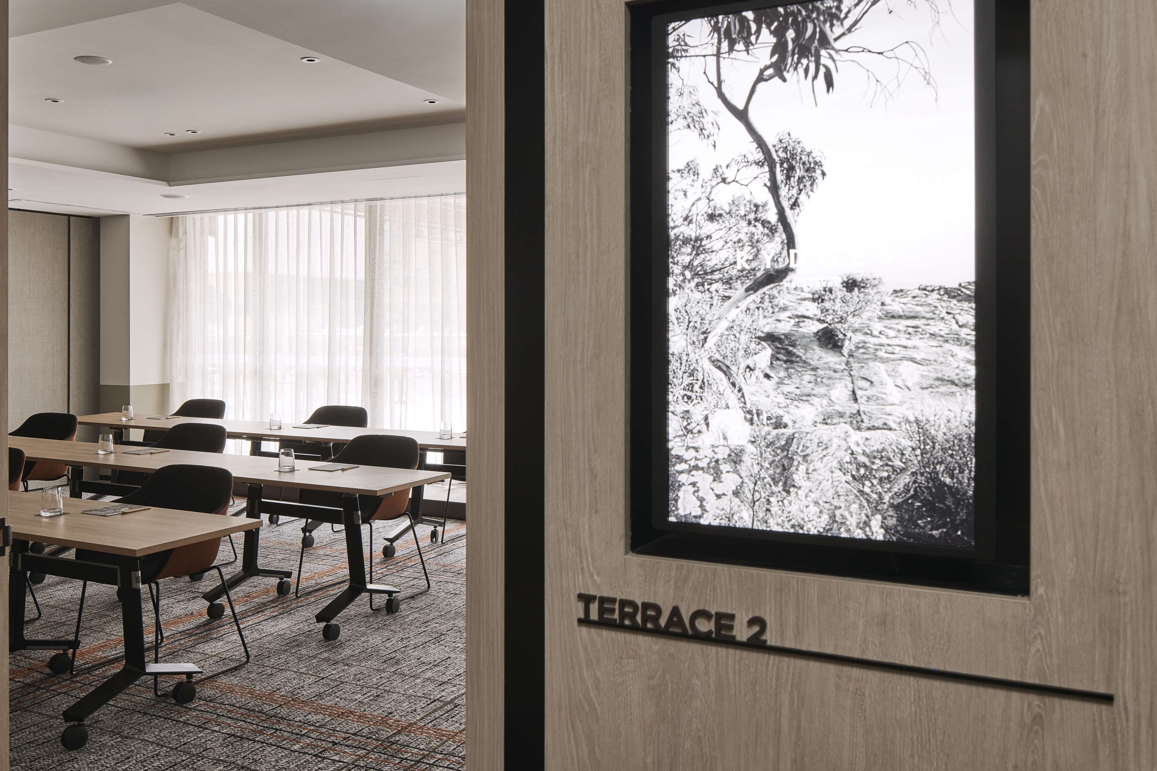 Une salle de conférence équipée de tables, de chaises et d’une grande fenêtre donnant sur un paysage enneigé.