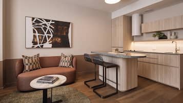 A modern kitchen with a central island, bar stools, and a built-in oven.