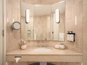 Un baño moderno con un espejo grande, un lavabo y un perchero para toallas.