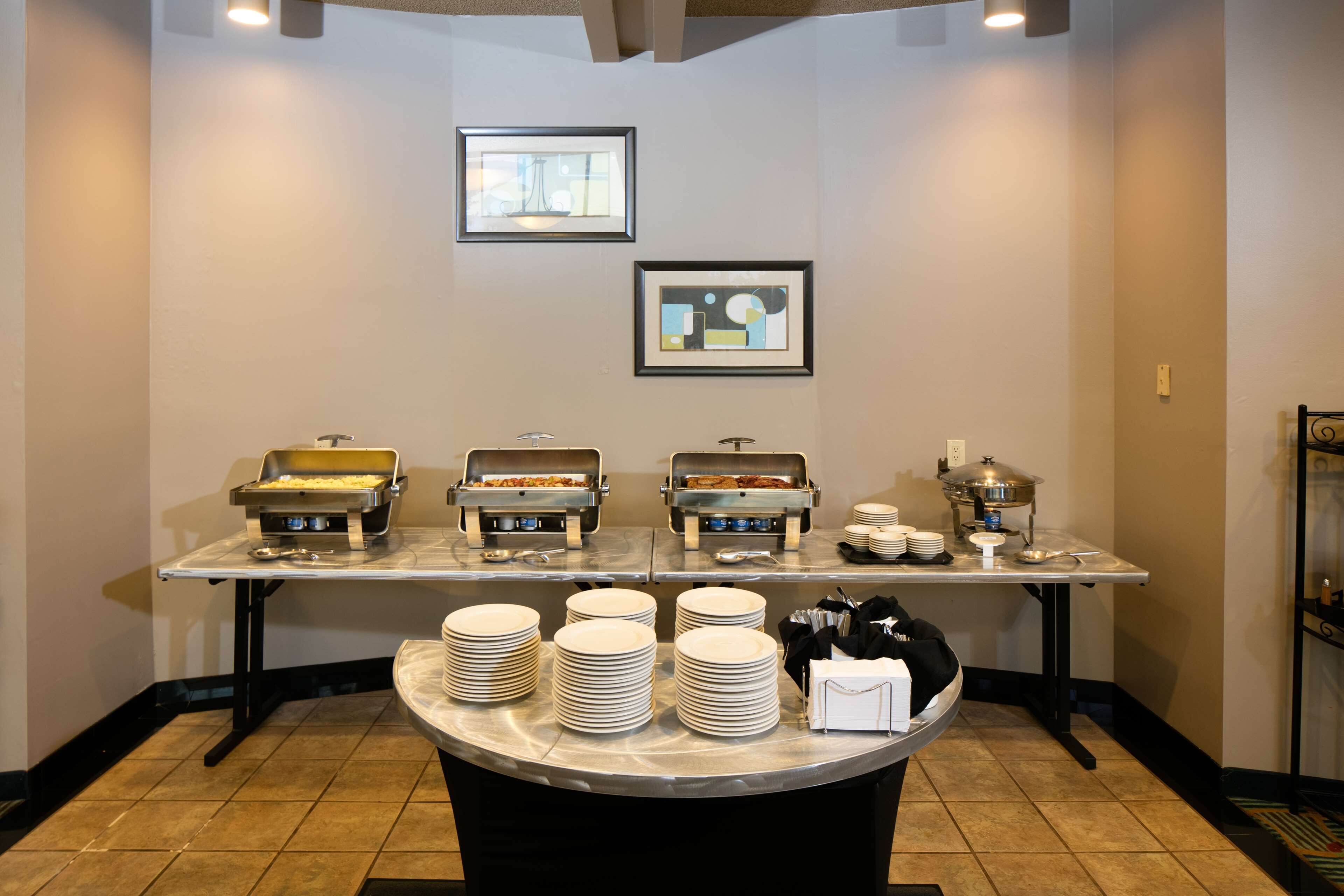 A buffet setup with multiple food stations, plates, and serving utensils.