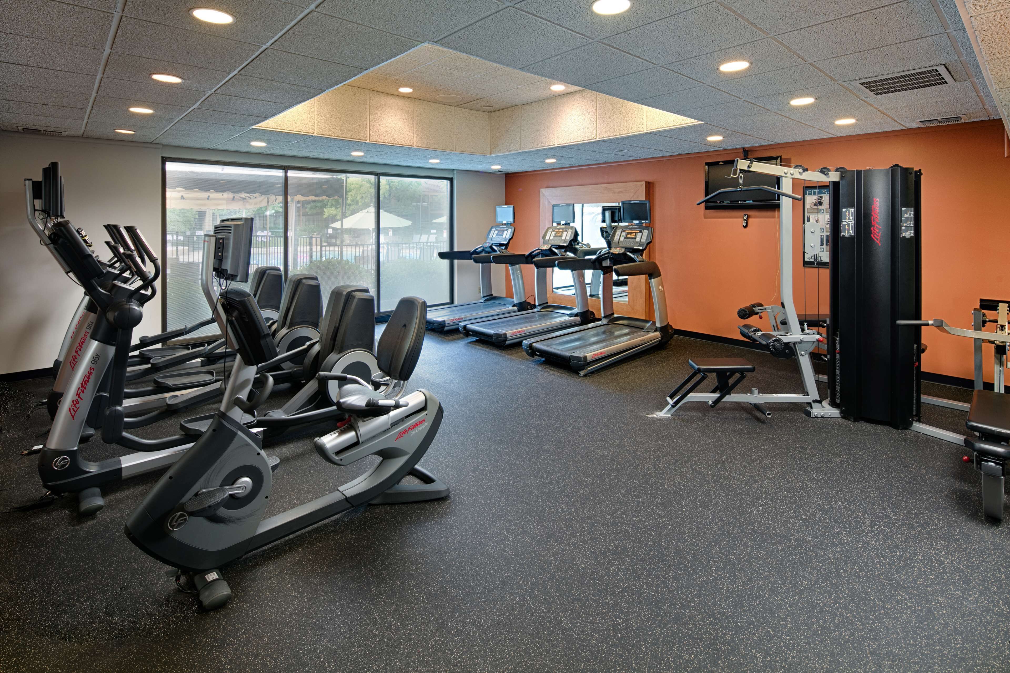 A gym with treadmills, elliptical machines, and weight equipment.