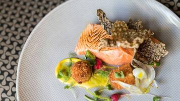 Ein Teller mit Lachs, panierten Speisen und Salat.
