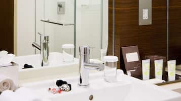 A modern bathroom with a large mirror, a sink, and a shower.