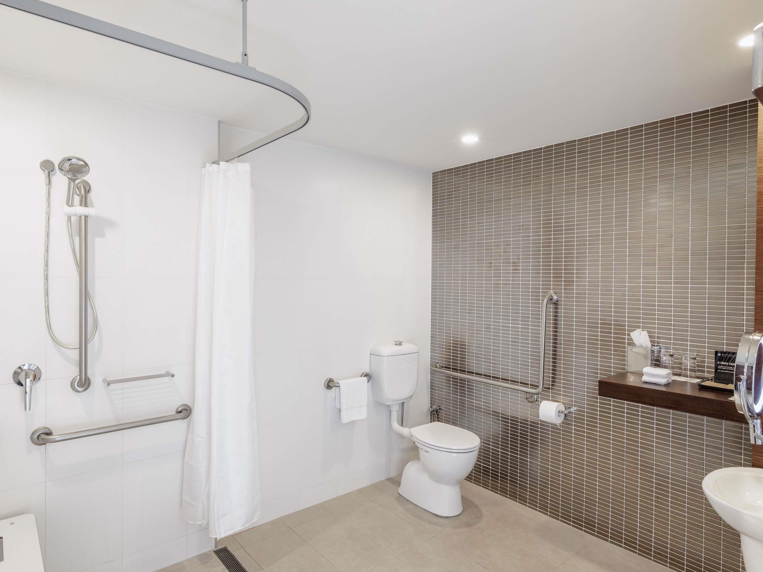 A modern bathroom with a shower, toilet, and sink.
