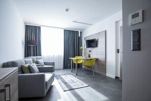 Suite ejecutiva, varias camas | Área de sala de estar | Televisión LCD y tenis de mesa 