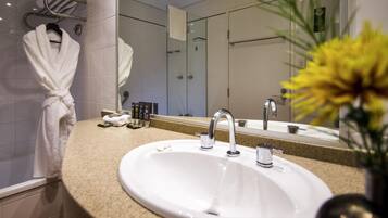 A bathroom with a sink, mirror, and towel rack.
