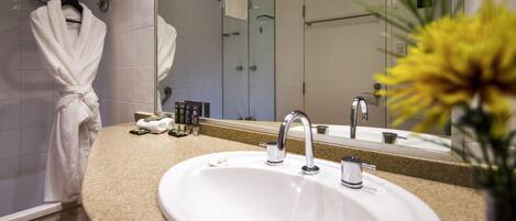 A bathroom with a sink, mirror, and towel rack.