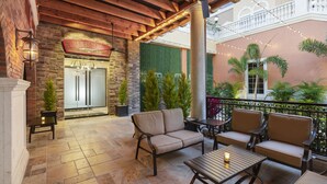 A covered patio area with stone flooring, outdoor seating, and a view of a building with a sign. - Westgate Town Center Resort (Kissimmee)