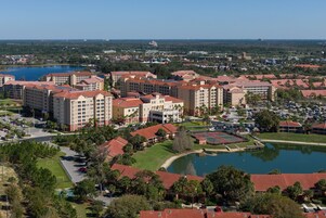Un resort con diversi edifici, un cortile centrale e un lago.