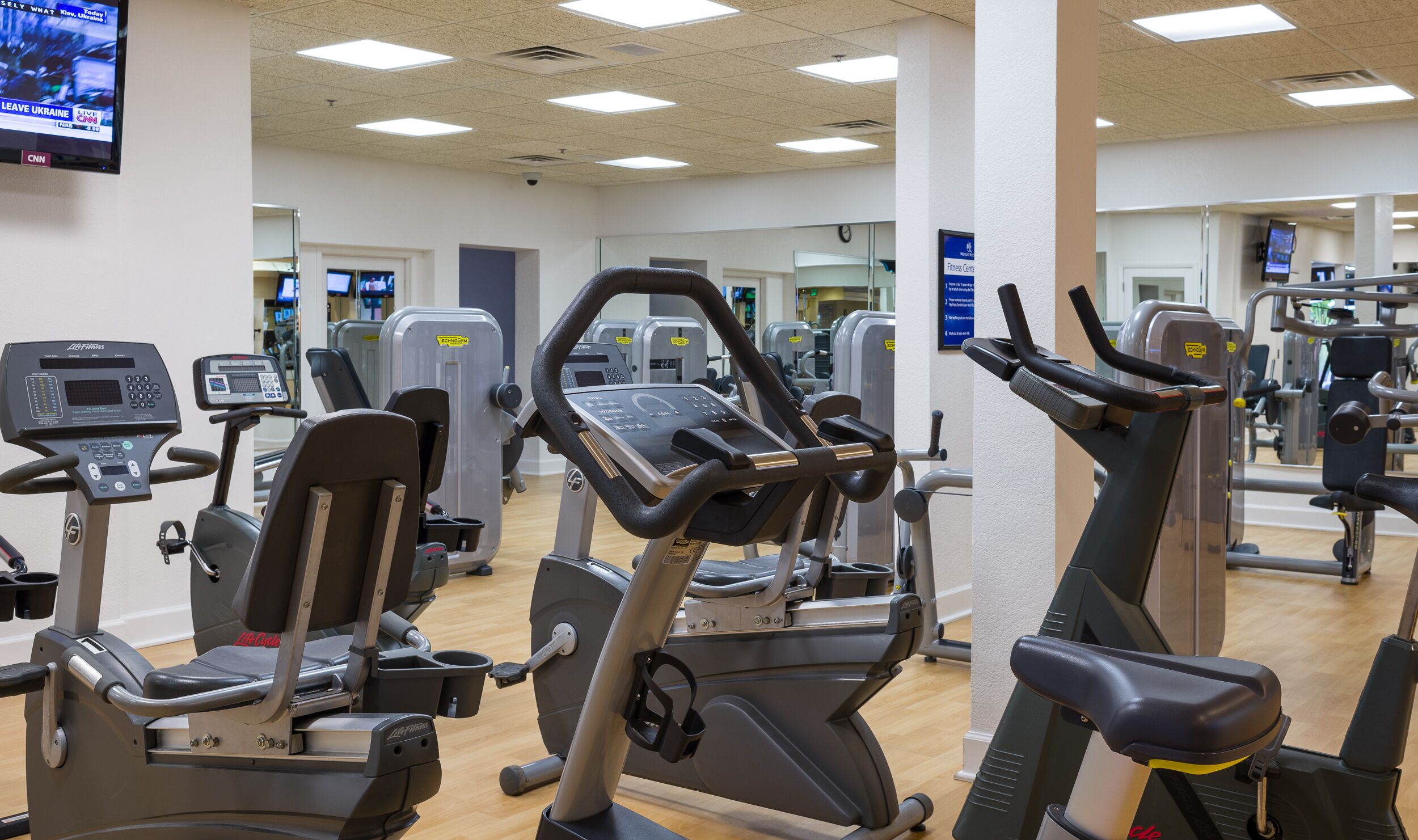 A gym with various exercise machines, including treadmills and elliptical trainers.