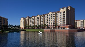 Un hotel grande con varios pisos y un patio central con un estanque y cisnes.