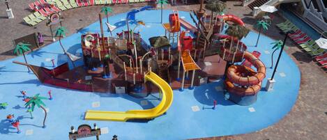 A water park with slides, a play area, and lounge chairs.