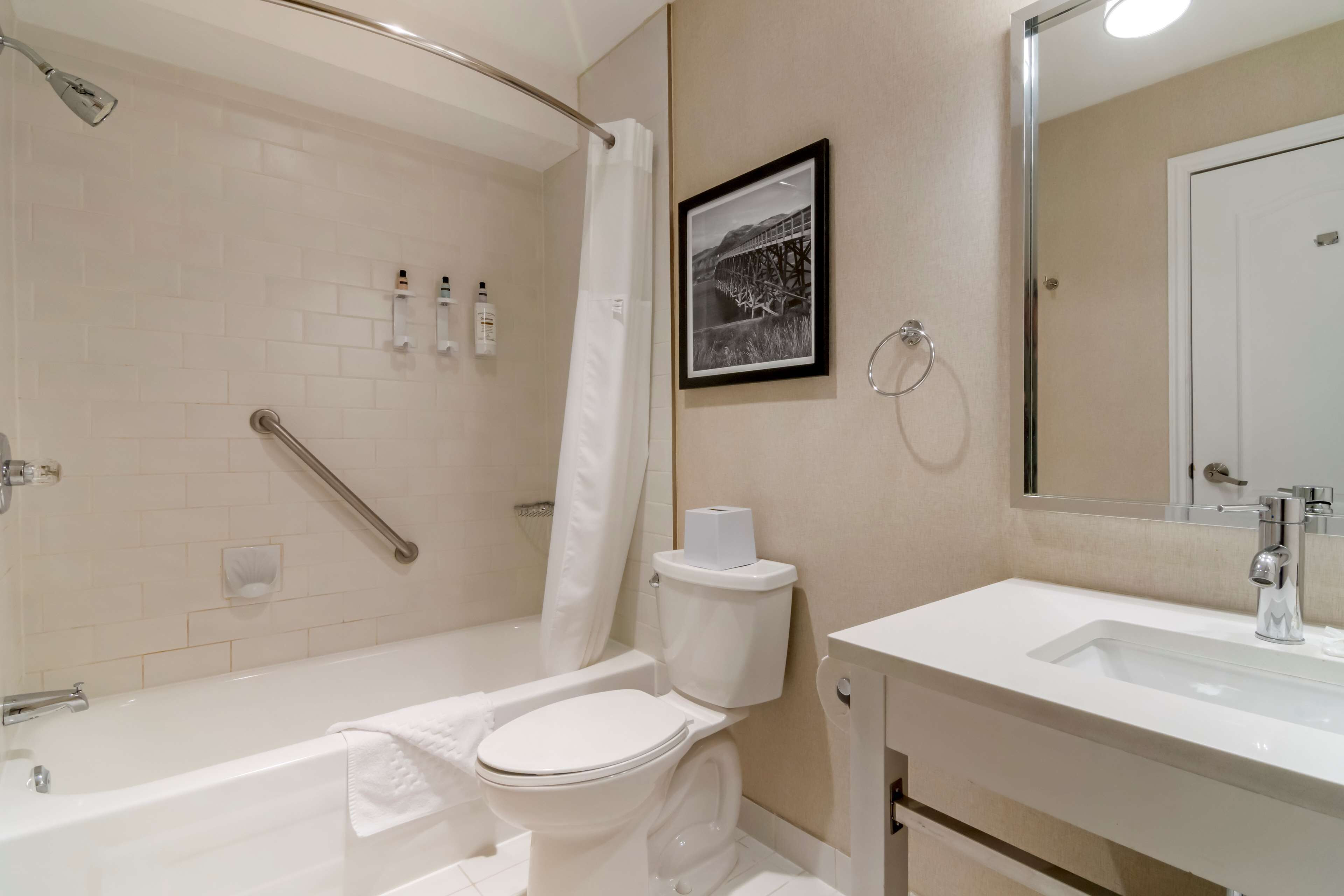 A modern bathroom with a bathtub, toilet, and sink.
