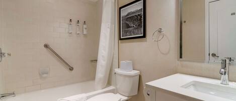 A modern bathroom with a bathtub, toilet, and sink.