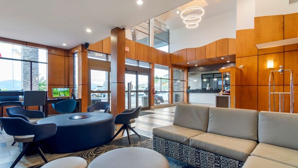 A modern lobby with a seating area, a reception desk, and large windows offering a view of the outdoors. - Best Western Premier Aberdeen Kamloops (Kamloops)