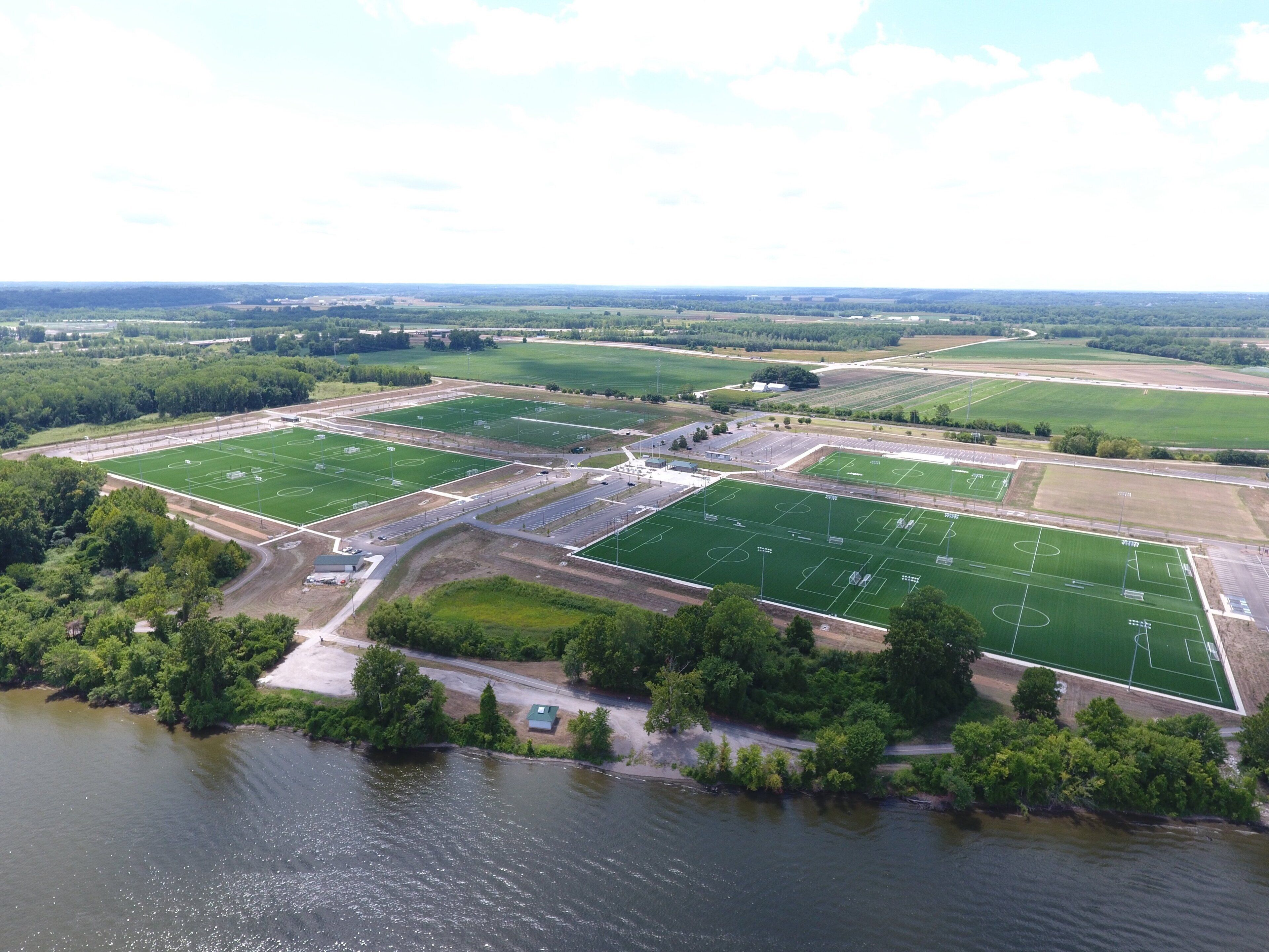 An aerial view of a sports complex with multiple fields and a parking area.