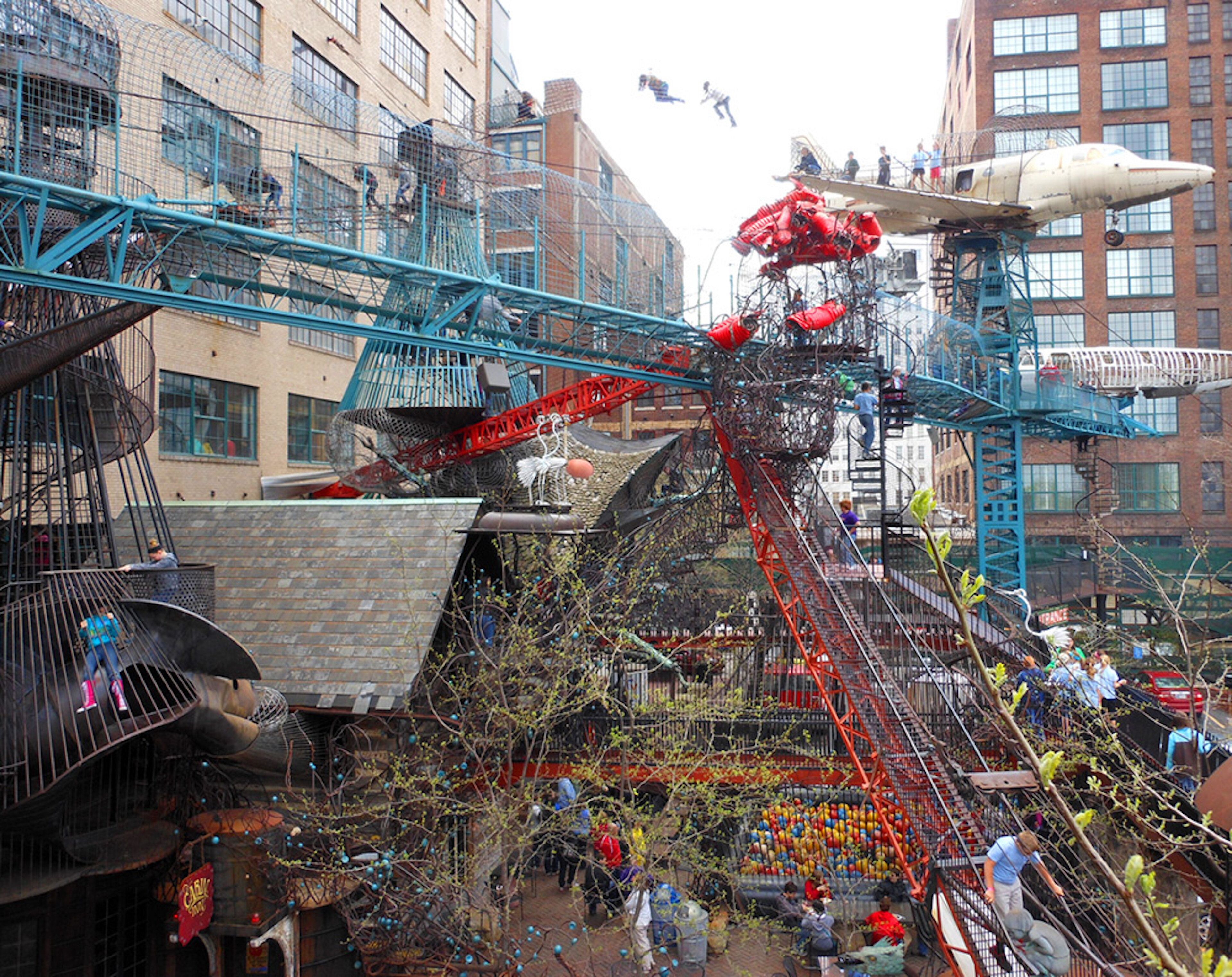 Una estructura exterior compleja con varios niveles y plataformas, rodeada de edificios urbanos.