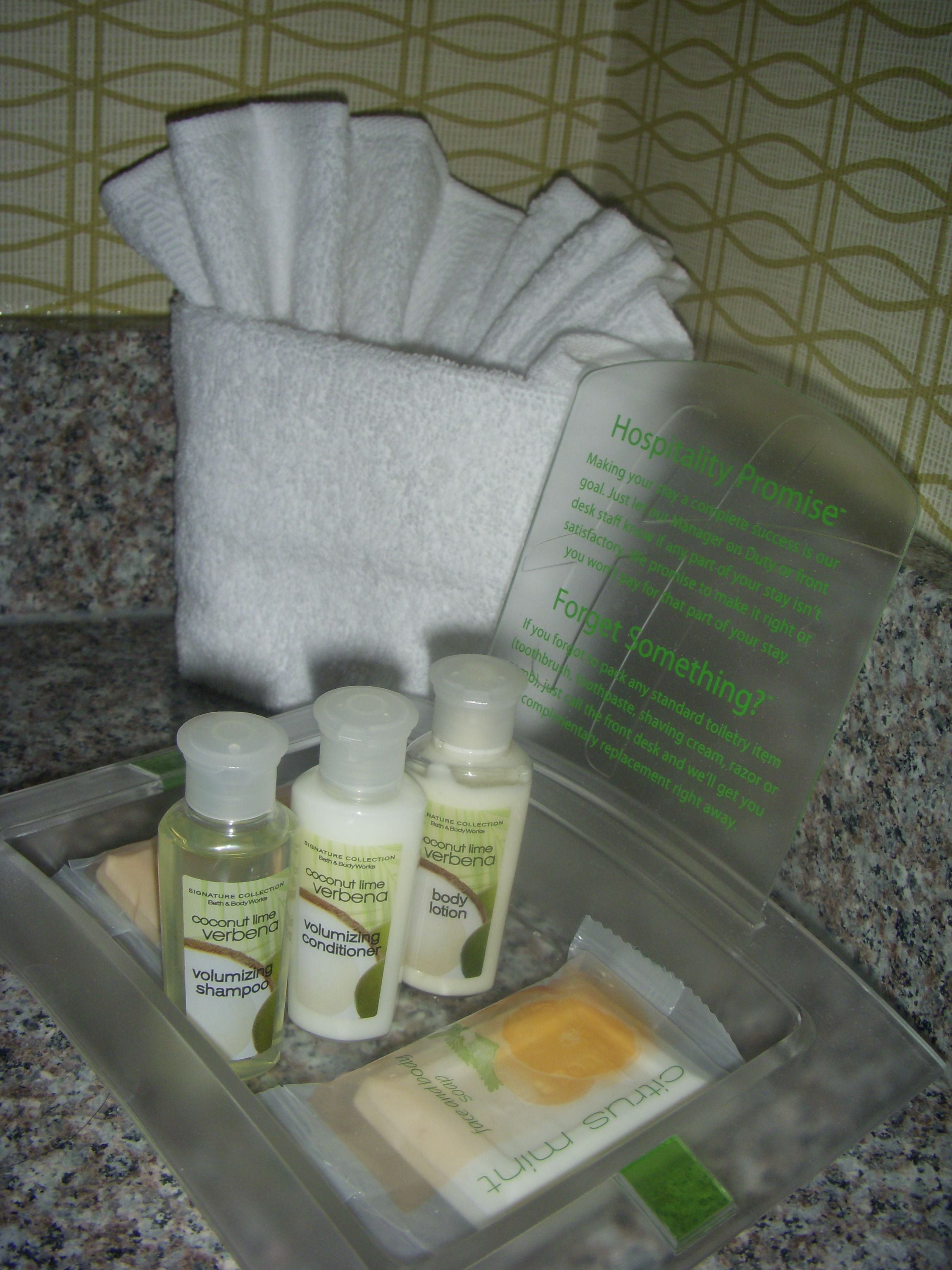 Toiletries in a hotel bathroom, including shampoo, conditioner, and lotion.