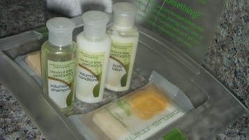 Toiletries in a hotel bathroom, including shampoo, conditioner, and lotion.