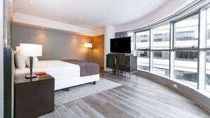 A modern hotel room with a large bed, a flat-screen TV, a desk, and a large window offering a city view. - DoubleTree by Hilton Buenos Aires (Buenos Aires)