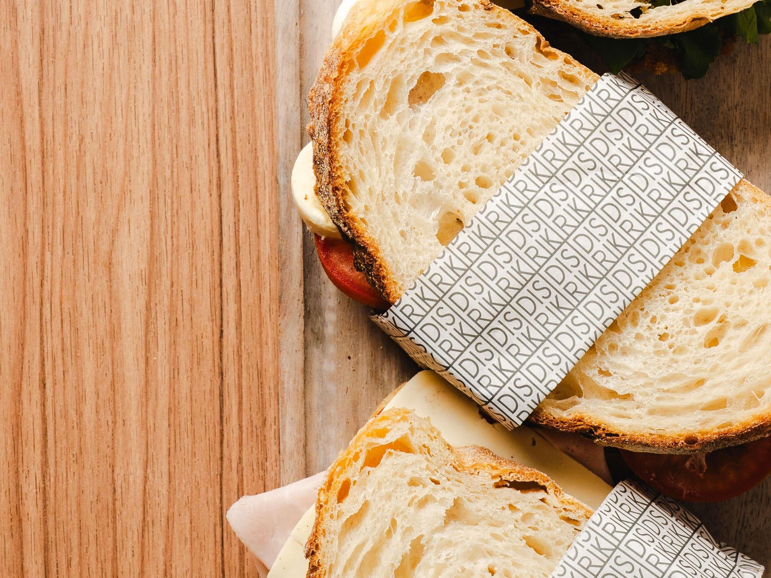 Rebanadas de pan con un papel estampado sobre una superficie de madera.