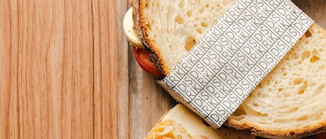 Rebanadas de pan con un papel estampado sobre una superficie de madera.