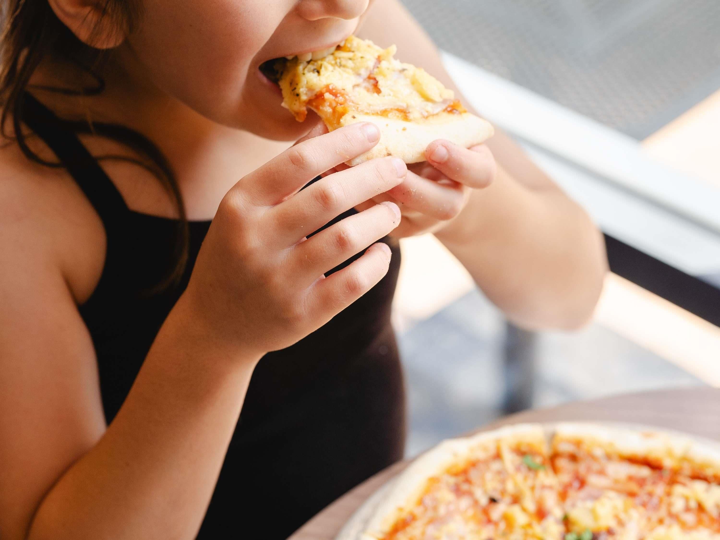 A person holding a slice of pizza.