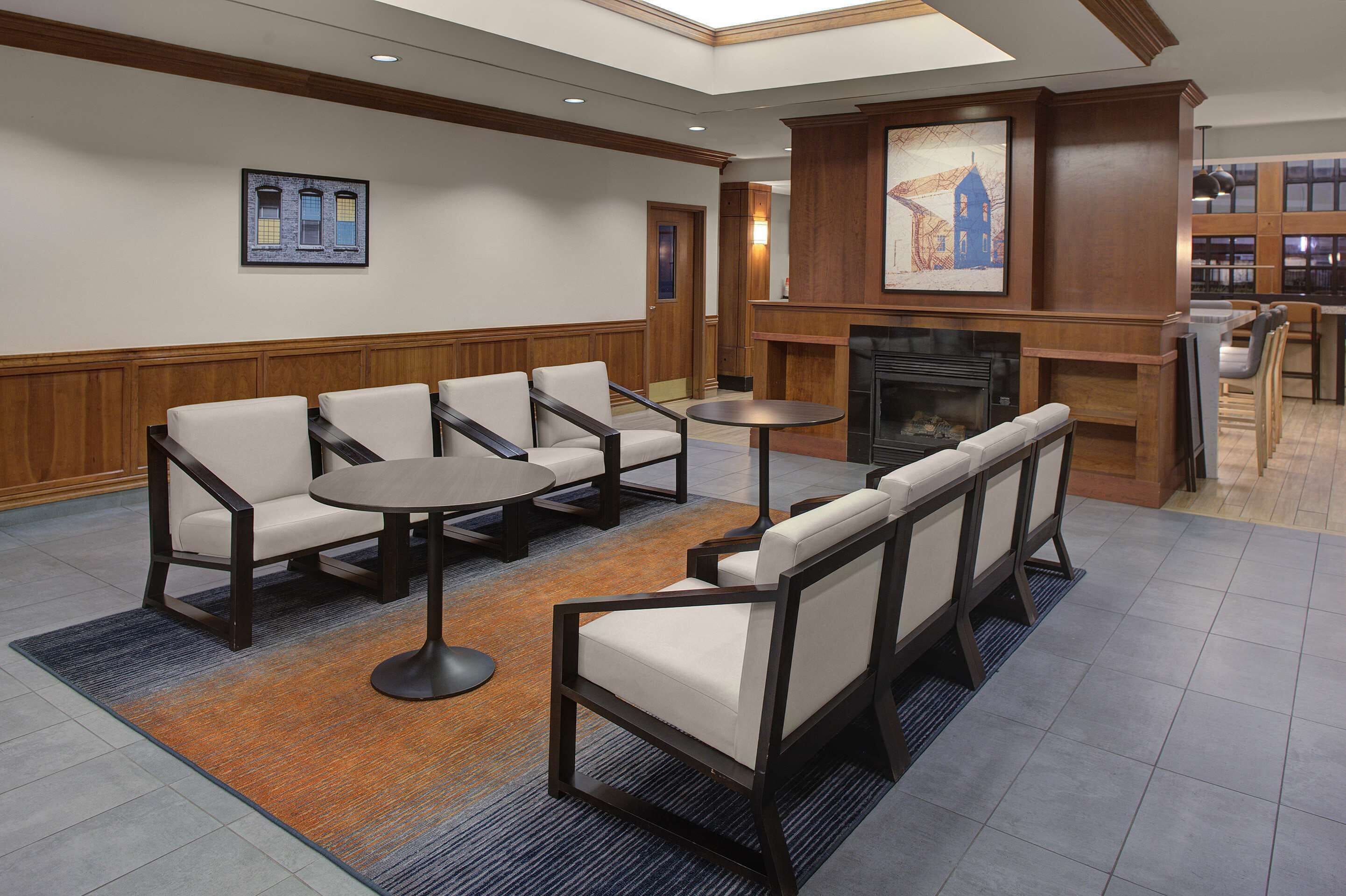 A lobby with seating areas, a fireplace, and a bar.