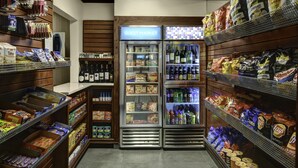 A grocery store aisle with refrigerated sections and shelves stocked with snacks and beverages. - HYATT house Philadelphia/Plymouth Meeting (East Norriton)