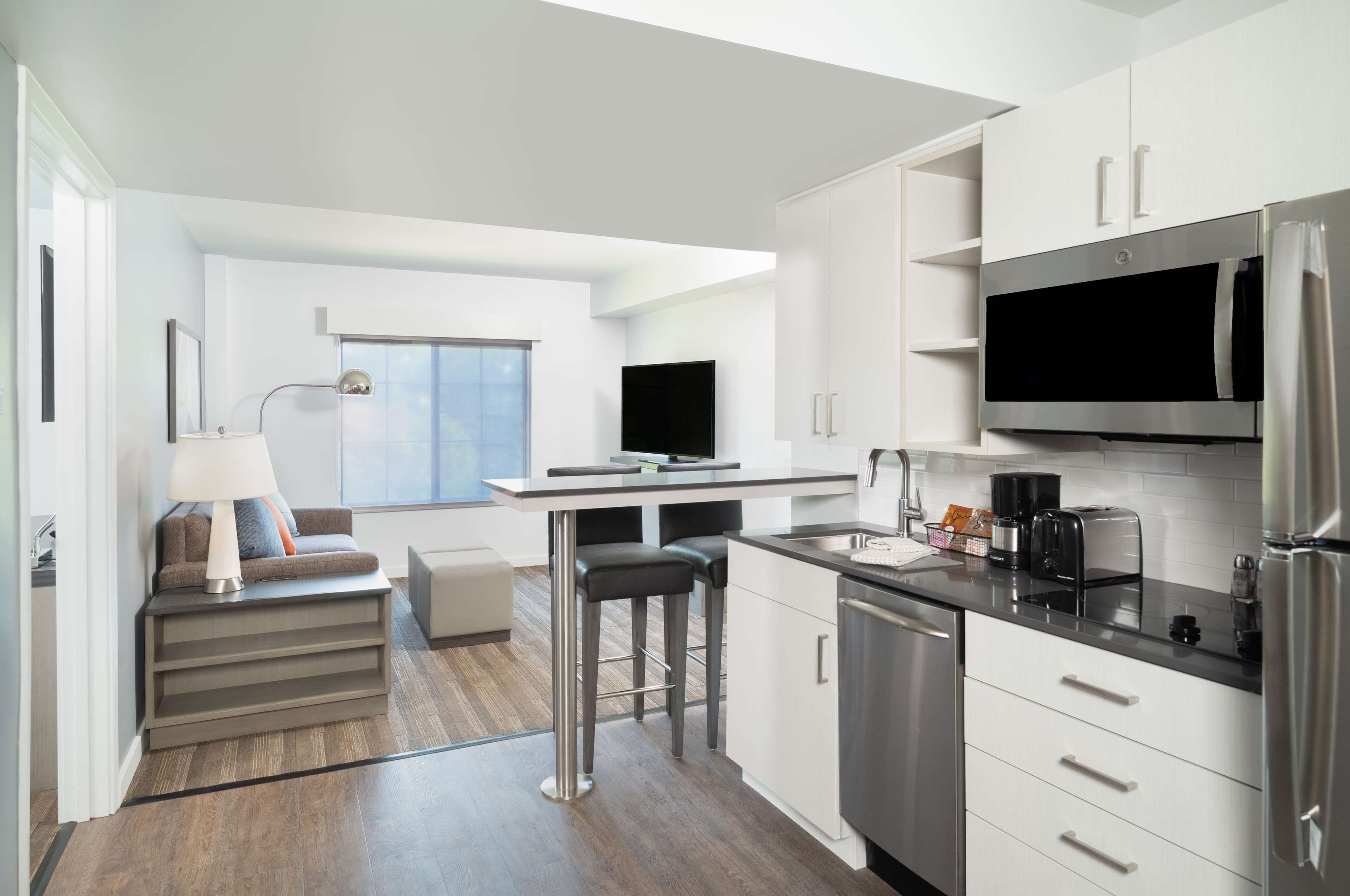 Una cocina moderna con comedor, electrodomésticos integrados y un amplio ventanal.