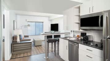 Una cocina moderna con comedor, electrodomésticos integrados y un amplio ventanal.