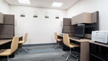 A conference room with cubicles, a desk with a computer, and a printer.