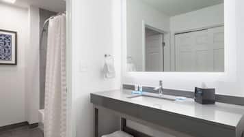 A modern bathroom with a shower, a sink with a mirror, and a towel rack.