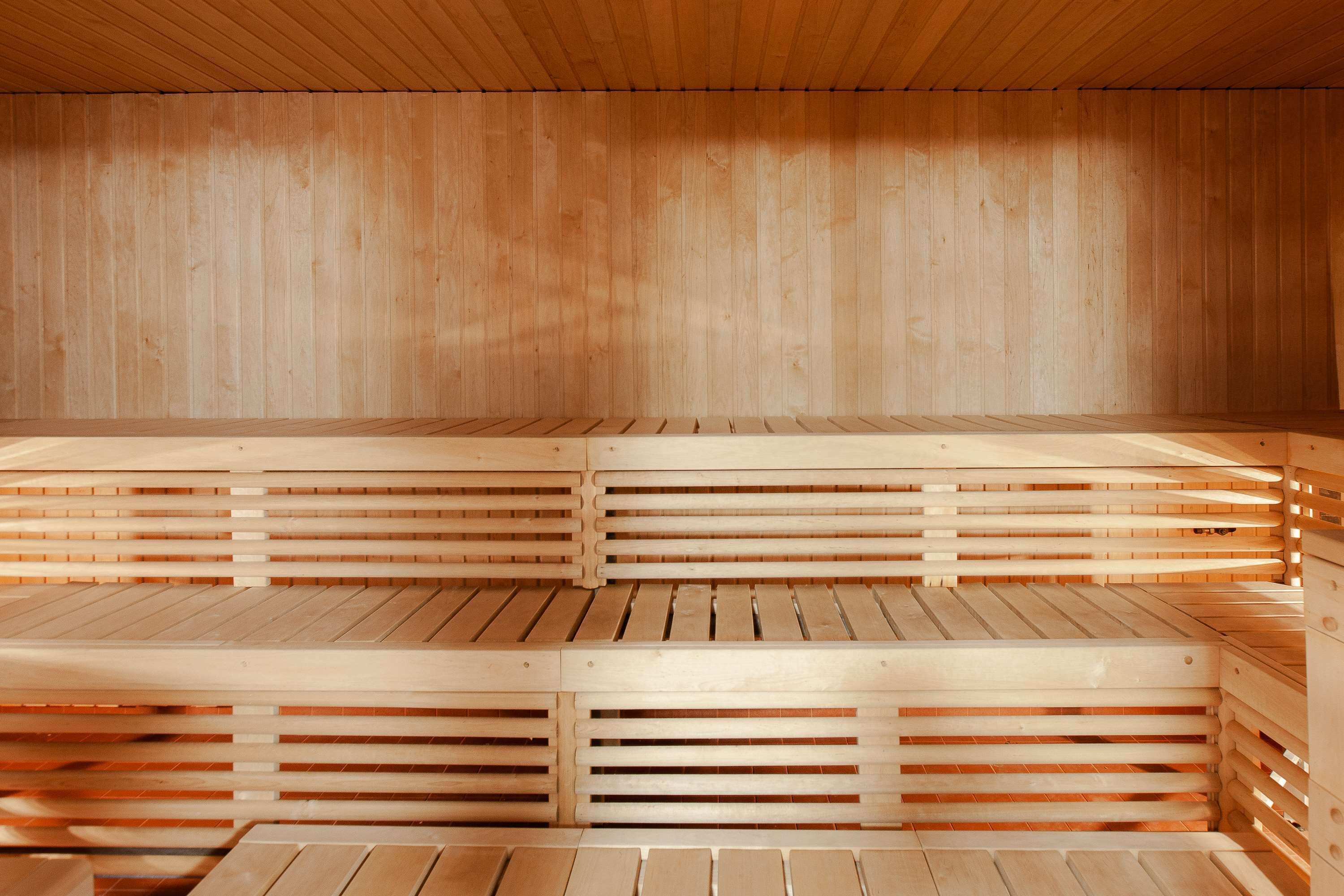 Una sauna con bancos de madera y paredes de listones.