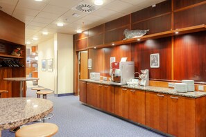 A hotel lobby with wooden paneling, a coffee station, and seating areas. - Scandic Mikkeli (Mikkeli)