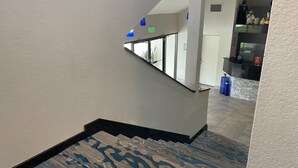 A staircase with a patterned carpet leading to a landing. - Destiny Palms Hotel Maingate West (Kissimmee)