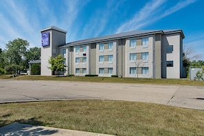 A Sleep Inn hotel with a modern design, featuring a parking lot and a well-maintained lawn.