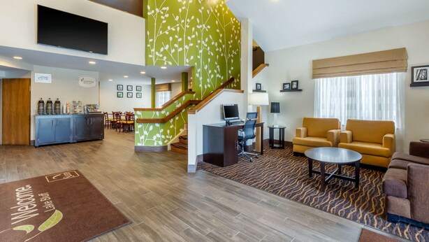 Eine Hotelhalle mit Treppe, Sitzgelegenheiten und einer Rezeption.