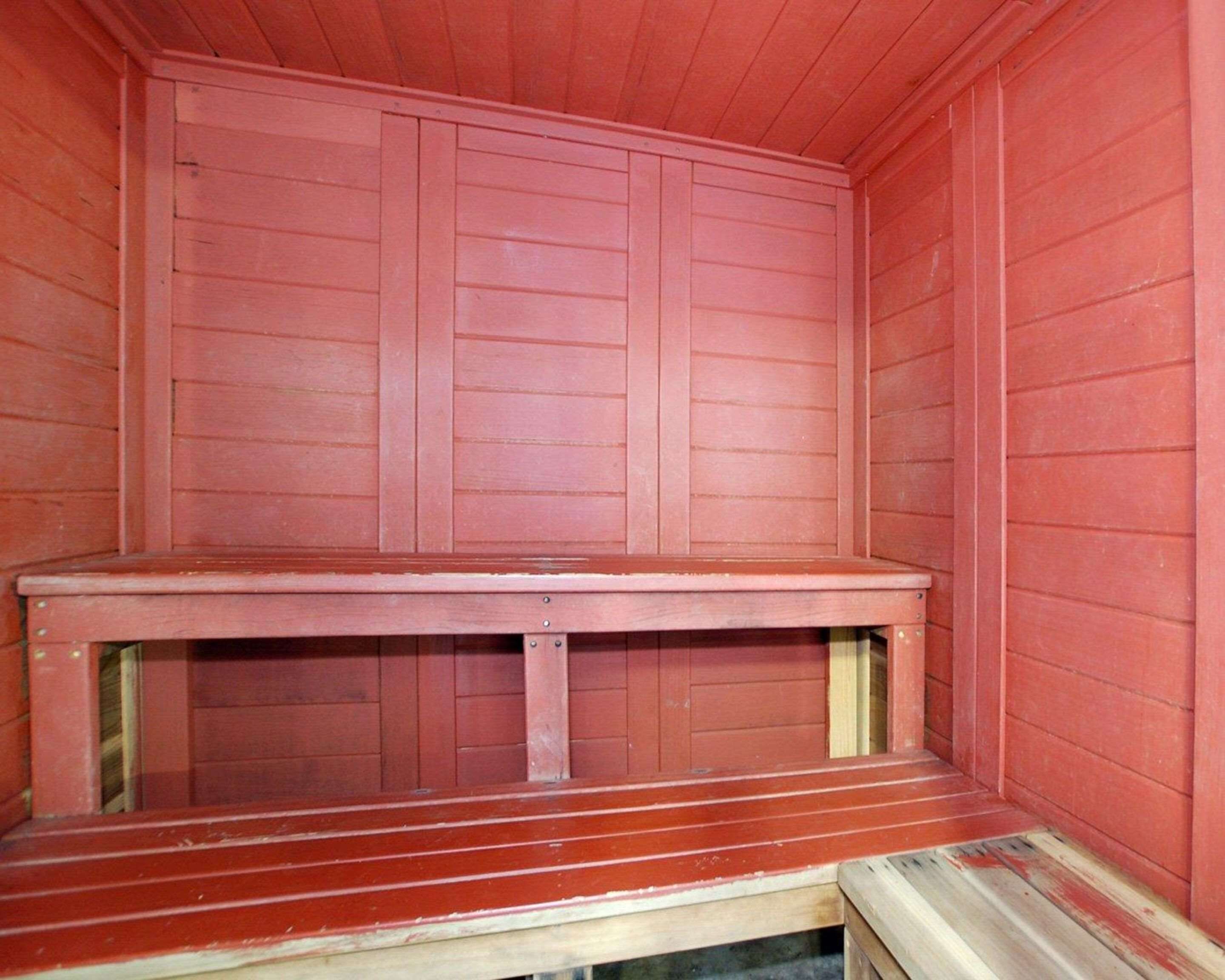 Een houten sauna met een bank en een houten vloer.