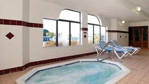 Un área de jacuzzi con vistas al exterior, suelo de baldosas y sillones de descanso.