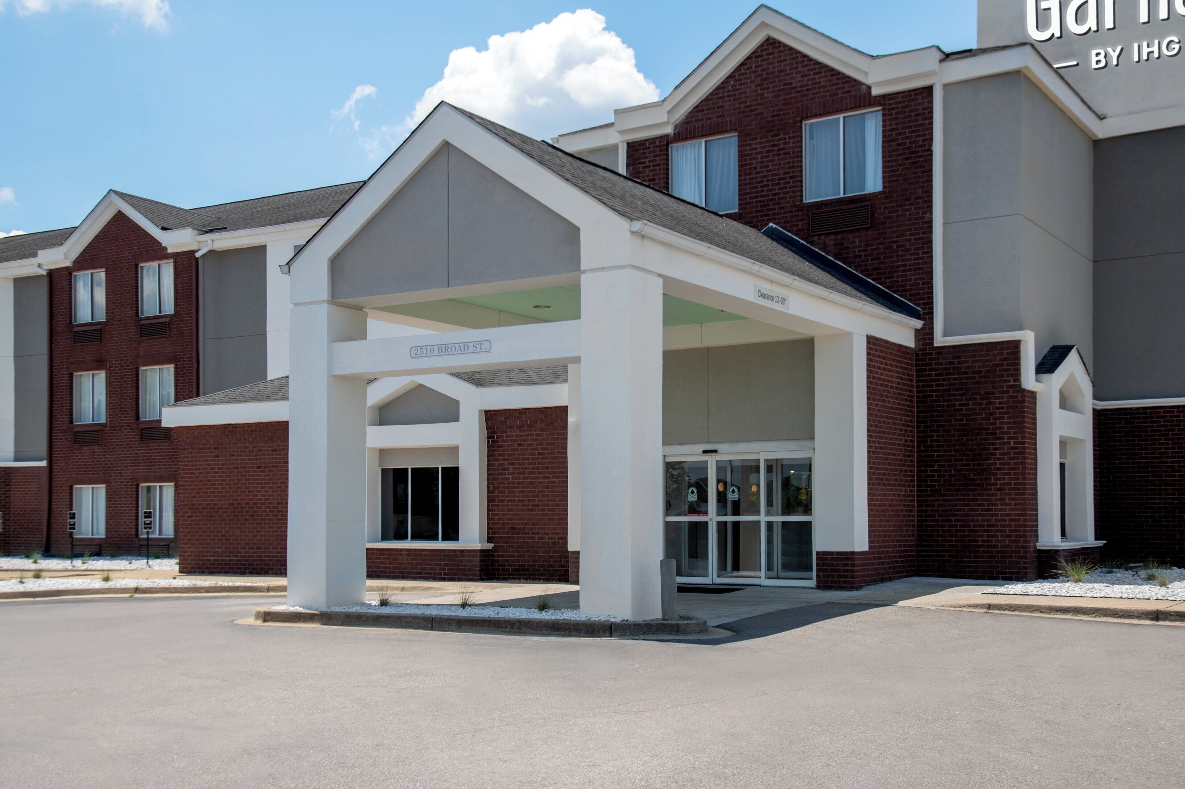 A multi-story building with a covered entrance and a sign indicating 'Clearance 12'-0' for vehicle access.