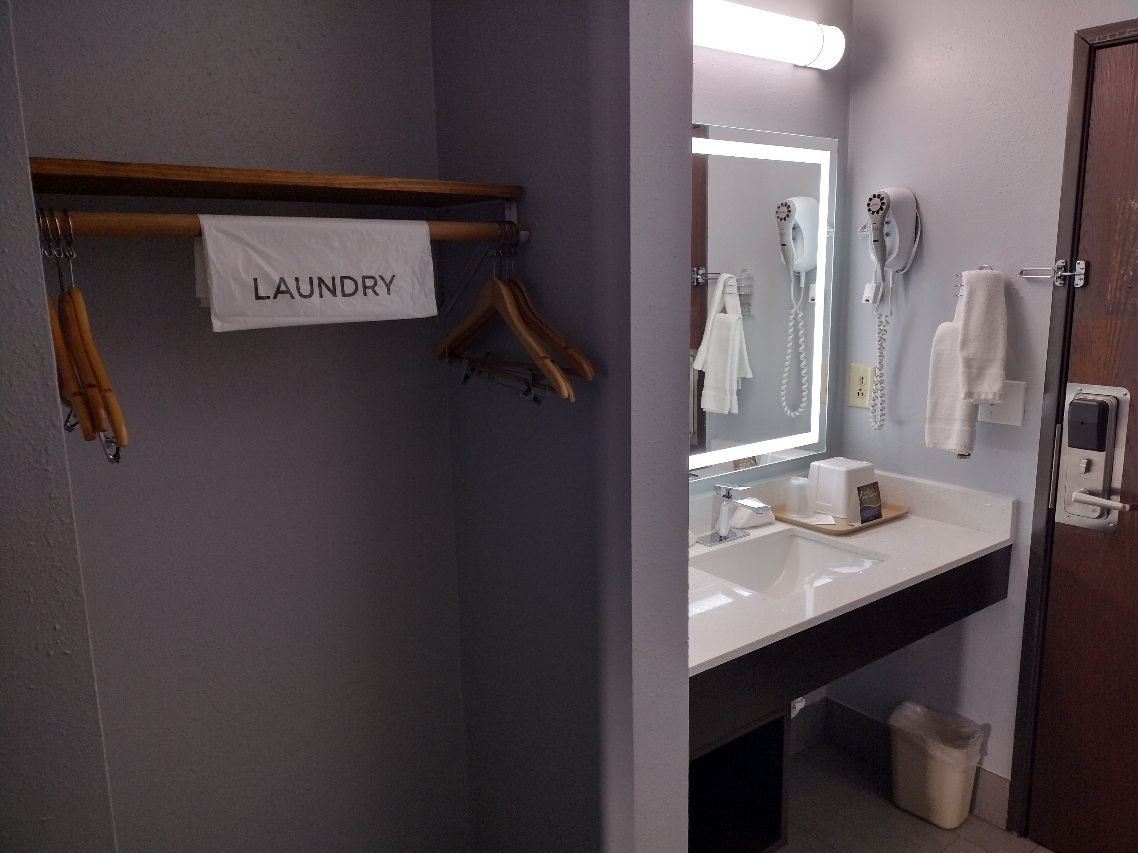Un baño con lavamanos, espejo, toallero y un letrero que dice "LAUNDRY".
